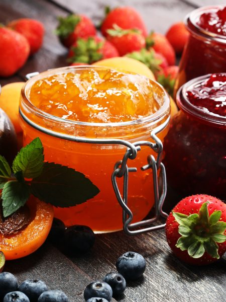 assortment of jams, seasonal berries, apricot, mint and fruits. marmalade or confiture